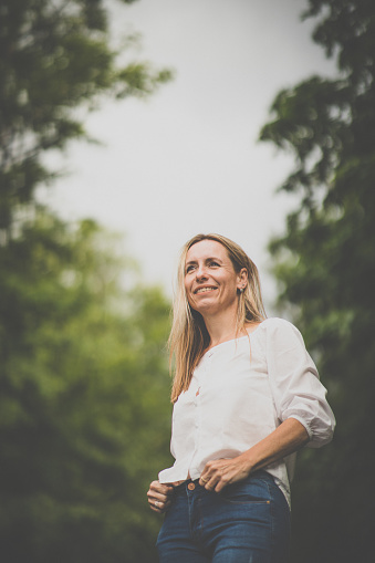 Portrait of a relaxed middle aged woman outdoors, looking happy, enjoying the life