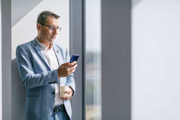 istock Mature businessman reading emails using smart phone 1305046794