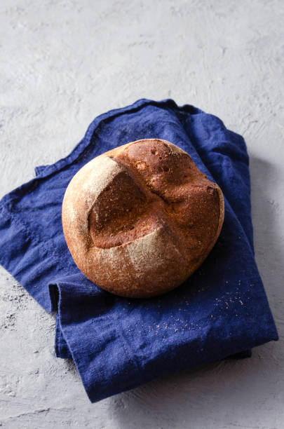 istock Vertical image.Rye bun on the blue napkin, grey table 1305047824