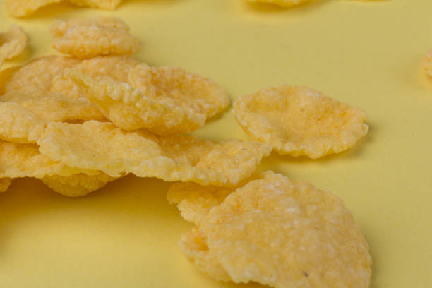 istock Pile of yellow cornflakes on yellow  background 1305048234