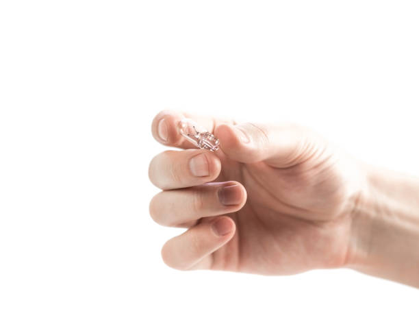 istock The hand holds a small glass light bulb. Close up. Isolated on a white background 1305048764