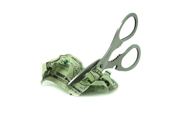 istock Abstract photo with iron scissors cutting crumpled counterfeit dollars isolated on white background 1305050961