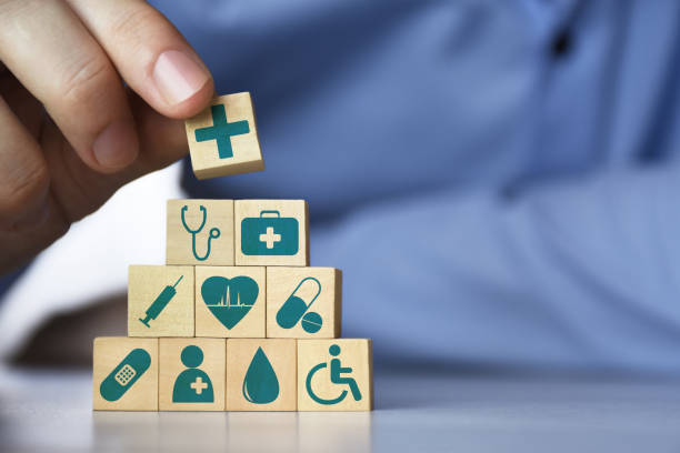 Medical health insurance concept. Men's hand arranging front view wood blocks with healthcare medicine icons