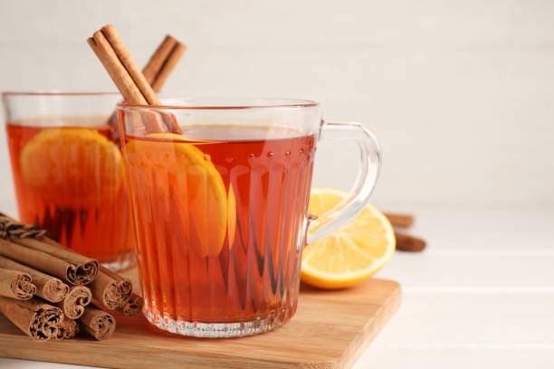istock Delicious hot tea with cinnamon and lemon on white wooden table, closeup. Space for text 1305059800