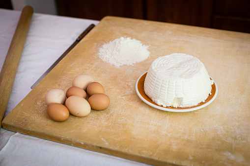 Eggs ricotta cheese and flour on a cuttbord