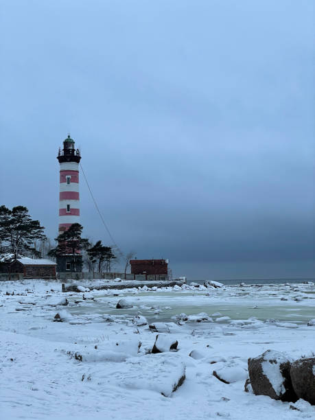 istock Old red and white lighthouse on a frozen lake 1305063794