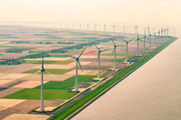 aerogeneradores frente a campos de flores de tulipán que crecen en primavera en la vista aérea de holanda - netherlands dyke polder aerial view fotografías e imágenes de stock