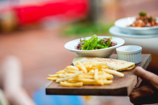 Waiter serves delicious food Unrecognazable waiter serving food in sidewalk cafe toasted sandwich stock pictures, royalty-free photos & images