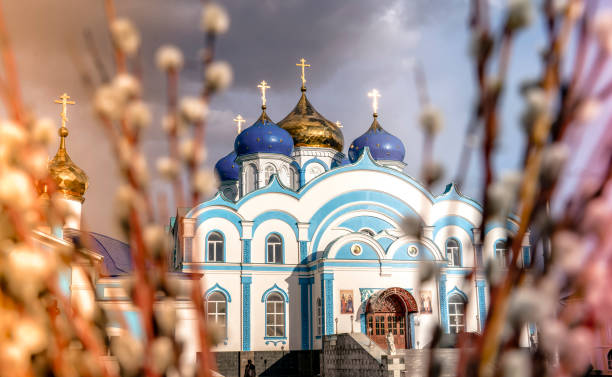 orthodox Christian cathedral of blue color through willow branches