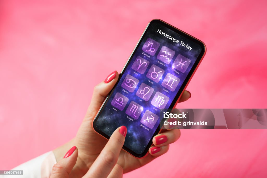 Person reading daily horoscope on mobile phone Person reading daily horoscope on her mobile phone Astrology Stock Photo