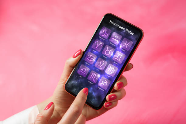Person reading daily horoscope on mobile phone Person reading daily horoscope on her mobile phone cancer astrology sign photos stock pictures, royalty-free photos & images