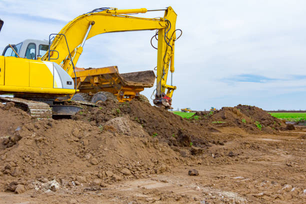 istock Excavator is loading a truck with ground on building site 1305069786