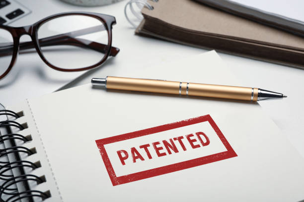 istock Notebook with stamp PATENTED and pen on table, closeup 1305070572