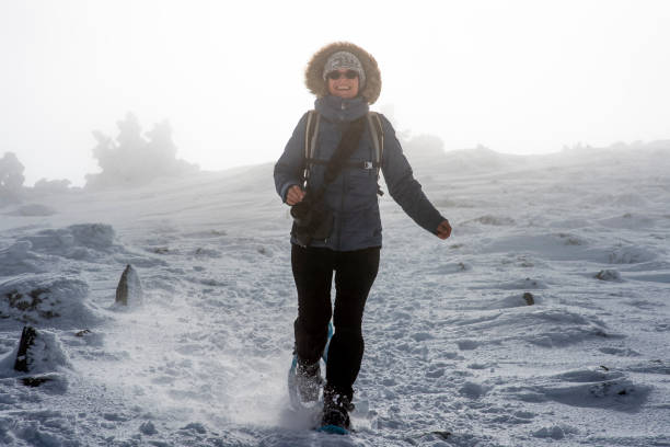 una donna corre nella neve con le ciasli - winter snowshoeing running snowshoe foto e immagini stock