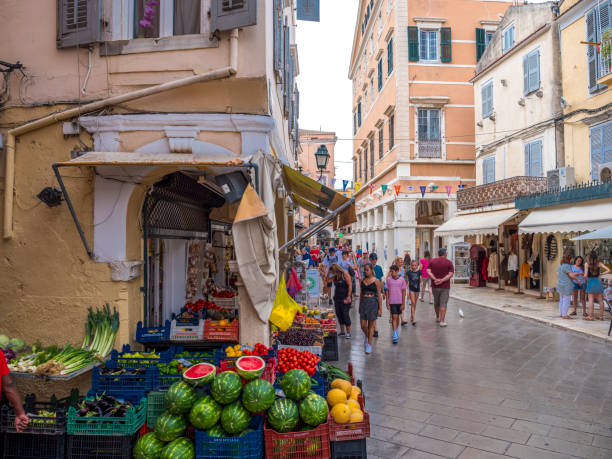 Narrow Shopping Street in Old Town Corfu, Greece Tourism, People shopping and eating on a narrow street in old town Corfu, Greece corfu town stock pictures, royalty-free photos & images
