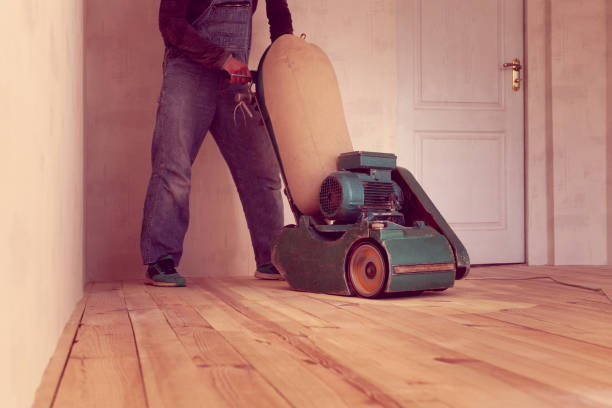 istock carpenter works by electric grinding wood machine in a room 1305076231