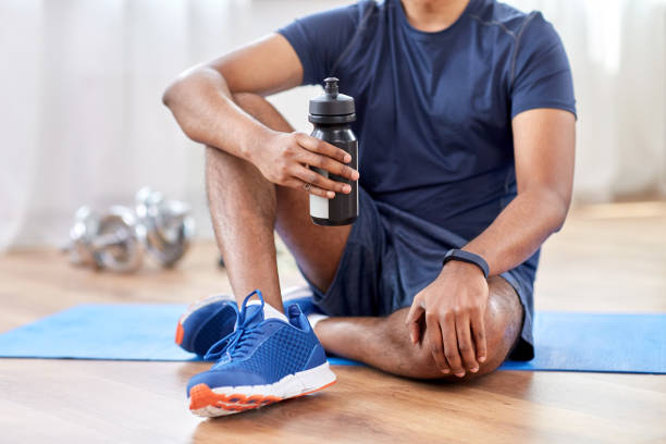 istock indian man drinking water after training at home 1305077925