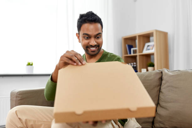 istock indian man looking inside of takeaway pizza box 1305078427