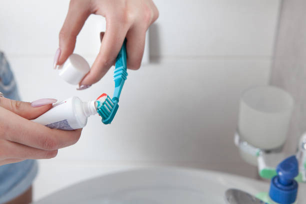 istock Young woman holding toothbrush before brushing teeth. 1305079657
