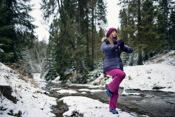 teenager-mädchen macht balance-übungen in der mitte des stromes im winter - nature zen like stream water stock-fotos und bilder