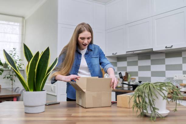 istock Young happy woman unpacking cardboard boxes, unboxing expected postal parcel 1305085274