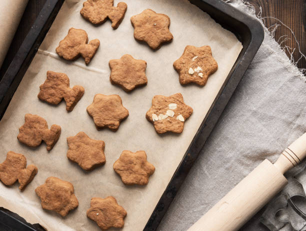 istock baked gingerbread cookies lie in a metal baking sheet on a brown table 1305086042