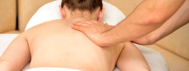 istock Masseur massaging back of woman 1305089022