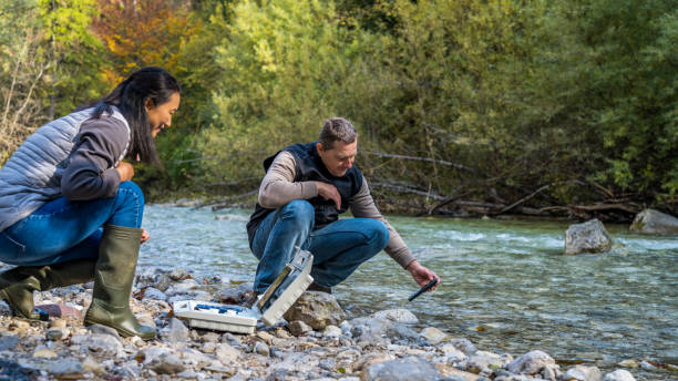 istock Two colleagues analyzing quality of water in clear mountain river. 1305091881