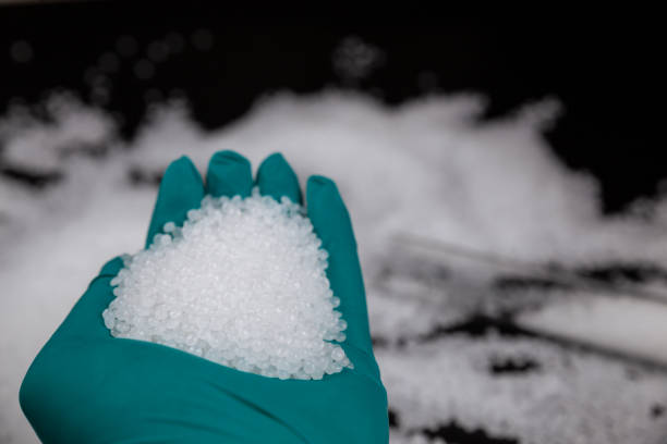 istock Close-up of plastic polymer granules. hand hold Polymer pellets. polymer plastic. compound polymer. Hands in rubber gloves hold plastic pellets. 1305092082