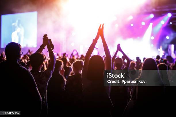 People With Raised Hands Silhouettes Of Concert Crowd In Front Of Bright Stage Lights Stock Photo - Download Image Now