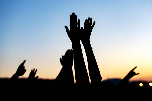 istock Raised hands of many people at a big mass event 1305092196
