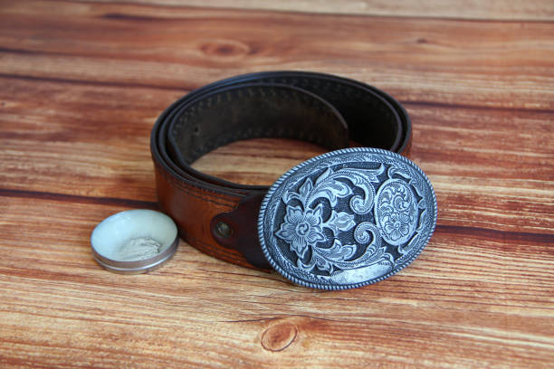 istock Leather cowboy belt with oval patterned buckle and cream for leather products 1305094859