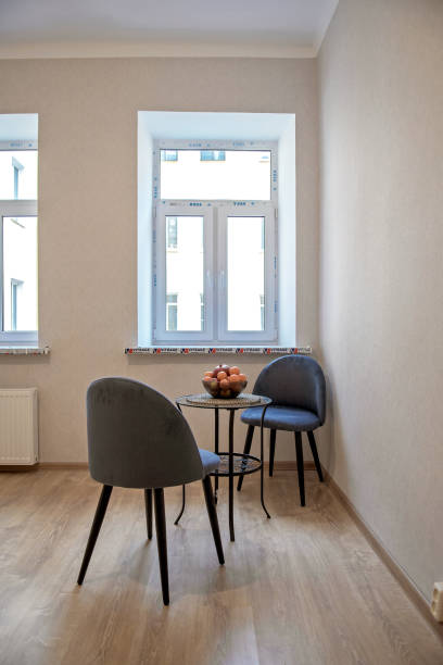 istock Modern interior design concept. Minimalistic style. Two blue armchairs and a table with fruit 1305097157