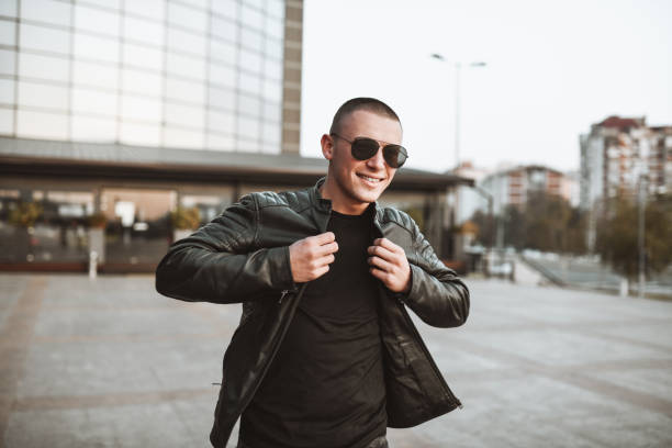 Modern Male Fixing Jacket While Walking Near Office Building