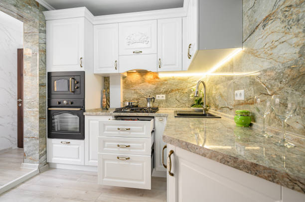 istock Drawers pulled out at modern classic white kitchen furniture 1305098418