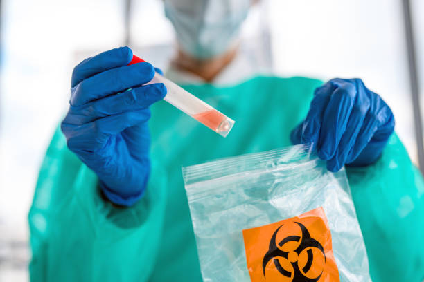 female doctor putting  sample of covid-19 test in biohazard bag - bio hazard imagens e fotografias de stock