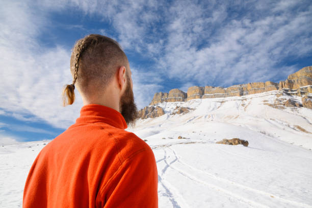 бородатый мужчина с жестокой стрижкой в красном свитере смотрит на эпические не криминальные скалы в солнечный день. концепция преодолени� - spit roasted audio стоковые фото и изображения