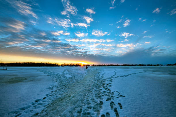 Frozen Lake at Sunset with frozen footprints in the Ice