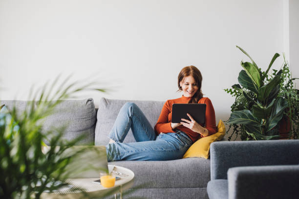 istock Women in Business: Smiling Young Businesswoman Using a Digital Tablet at Home 1305103328