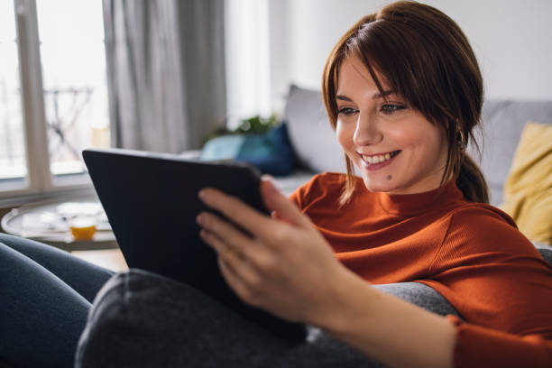 istock Women in Business: Smiling Young Businesswoman Using a Digital Tablet at Home 1305103395