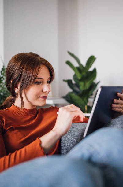istock Women in Business: Smiling Young Businesswoman Using a Digital Tablet at Home 1305103399