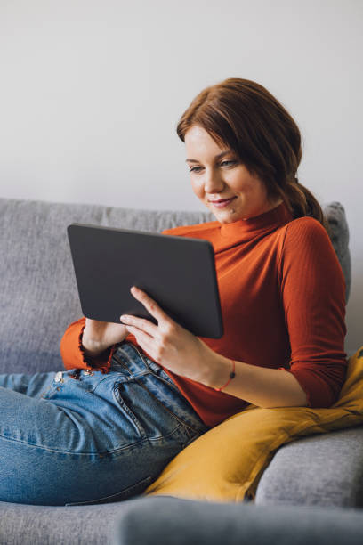 istock Women in Business: Smiling Young Businesswoman Using a Digital Tablet at Home 1305103411