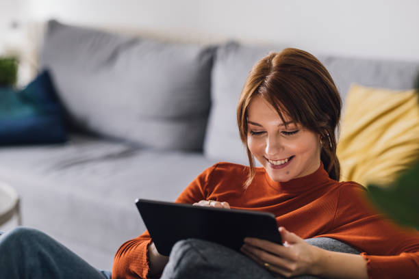 istock Women in Business: Smiling Young Businesswoman Using a Digital Tablet at Home 1305103422