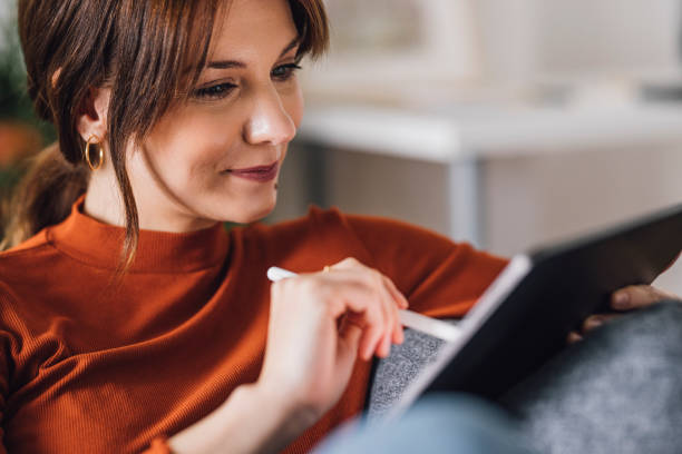 istock Women in Business: Smiling Young Businesswoman Using a Digital Tablet at Home 1305103428