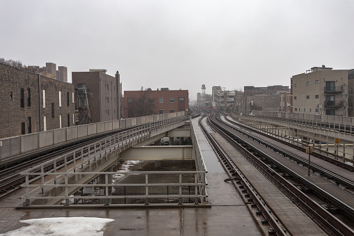 Wet empty elevated subway tracks on overcast day in urban Chicago