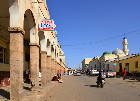 Asmara, Eritrea: view eastwards from Eritrea Square along Barentu Street - domes of the Grand Mosque Al Kulafah Al Rashidan on the left and colonial arcade for retail commerce on the right, Degghi Selam Chapel in the background - Asmera, a Modernist City of Africa - UNESCO World Heritage Site.