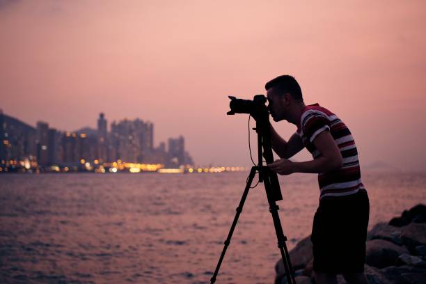 istock Silhouette of photographer with tripod 1305107087