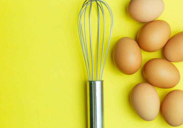istock Chicken eggs, brown eggs, broken egg in carton box on yellow background. Top view natural eggs in carton box product concept. 1305111278