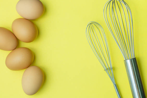 istock Chicken eggs, brown eggs, broken egg in carton box on yellow background. Top view natural eggs in carton box product concept. 1305111341