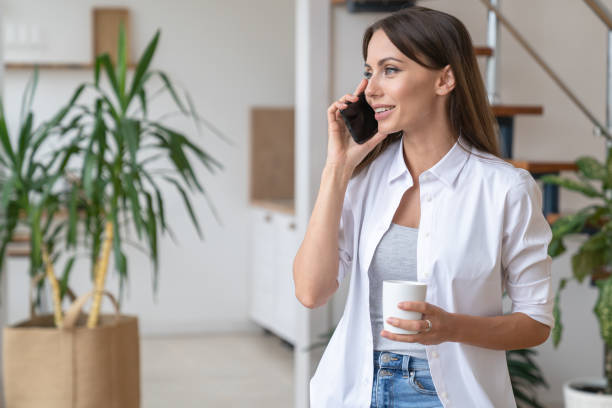 istock Woman Talking Over Phone While Holding Coffee Cup 1305112125